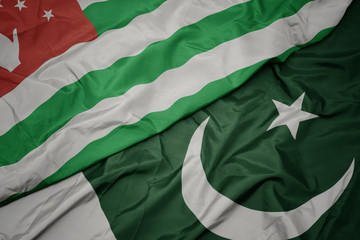 waving colorful flag of pakistan and national flag of abkhazia.