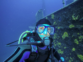 Naklejka na ściany i meble Scuba Diver Portrait Beside Large Shipwreck
