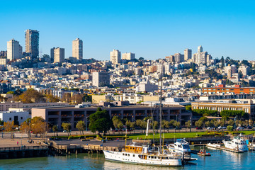 Obraz premium San Francisco, California cityscape and skyline. Yachts and boats berthed by the coastal waterfront, high rise skyscraper buildings and other modern architecture fill the dense west coast city.