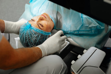 Obraz premium Top view of a serious nice woman during the eyesight examination
