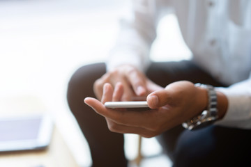 close up adult executive businessman holding smartphone to checking work and email alert or contact with employee from company after finish meeting conference , business lifestyle concept