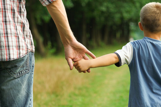the parent holds the hand of a l child