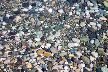 Sea stones in sea water. Pebbles under water. The view from the top. Nautical background. Clean sea water. Transparent sea.