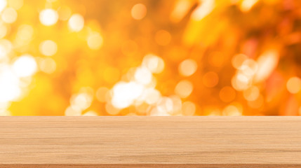 abstract blurred leaves of tree in orange color nature forest with sunny and bokeh light  and wood...