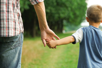 the parent holds the hand of a l child