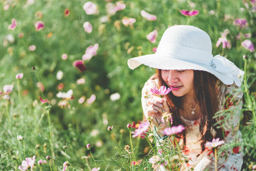 younger Asian women sitting, seeing and smelling flower flavour