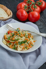 Italian pasta in a sauce with shrimps on a plate, top view. Dark wooden background. Space for text.