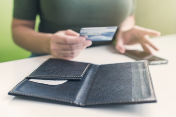 Cropped image of  woman hands with folder and bill on the table of cafe. visitor of restaurant...