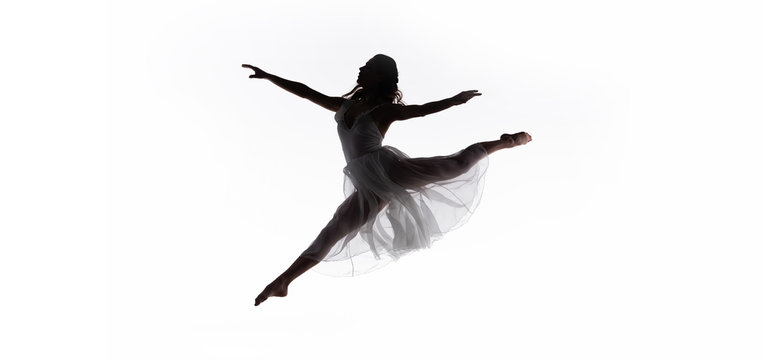 panoramic shot of young graceful ballerina jumping while dancing isolated on white