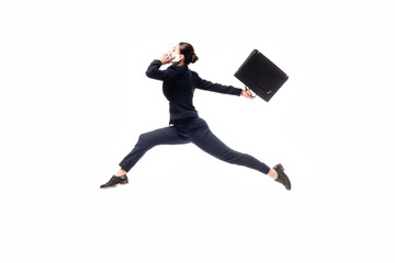 side view of businesswoman holding briefcase and talking on smartphone while levitating isolated on...