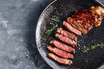 Rolgordijnen New York Strip steak medium rare with rosemary top view  © Anntuan