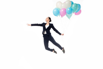 Fototapeta na wymiar happy businesswoman levitating with festive balloons isolated on white