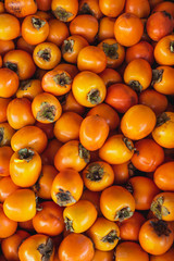 Top view food background of ripe persimmons at weekly spanish market