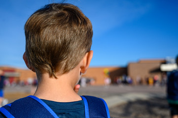 Caucasian boy with back pack on first day of school 