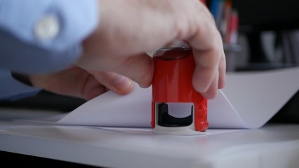 Manager Hand Stamping Papers and Documents Using a Rubber Stamp