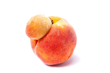 Fototapeta na wymiar Trendy ugly food. Peach orange fruit isolated on white background. Misshapen produce, food waste problem concept.