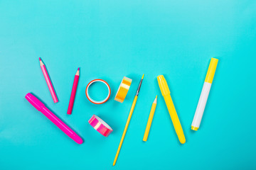 School items as a frame on blue background. Trendy colors, flat lay style. Back to school concept.