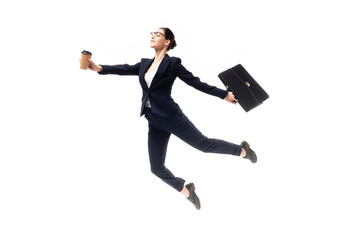 young attractive businesswoman holding coffee to go and briefcase while levitating isolated on white