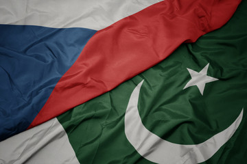 waving colorful flag of pakistan and national flag of czech republic.
