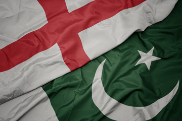 waving colorful flag of pakistan and national flag of england.