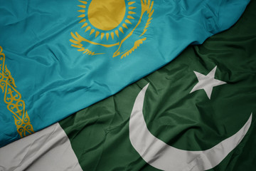 waving colorful flag of pakistan and national flag of kazakhstan.
