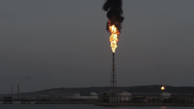 Gas flare and smoke of petrochemical refinery in twilight