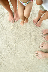Family feet on the sand on the beach
