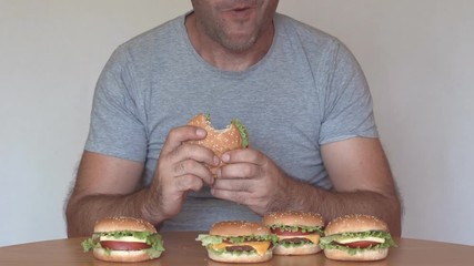 Hungry man eating fast food hamburger. Unhealthy eating