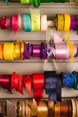 Colorful ribbons on special stands in a flower shop. Textile tapes in rolls