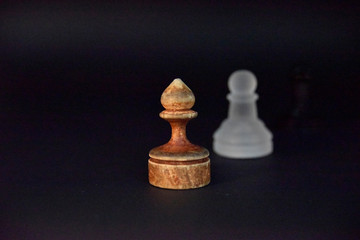 Old wooden ponce on the dark background and white glass ponce aside