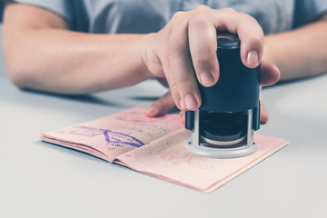 Immigration and passport control at the airport. woman border control officer puts a stamp in the...