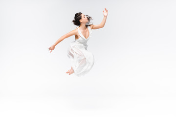 beautiful, graceful ballerina jumping in dance on grey background