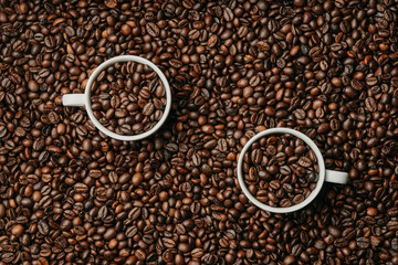Two cups of fresh roasted coffee beans