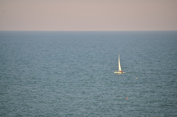 Fototapeta premium Sailboat sails gently on the sea