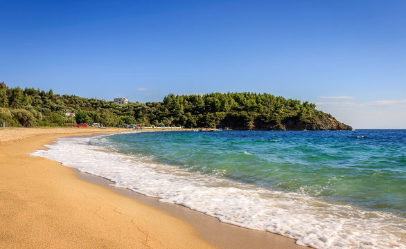 Beautiful, unique Aretes beach on Sithonia with golden sand, foamy waves and turquoise water