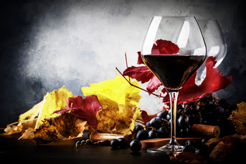 Dry Red wine in wine glass, fall still life with red and yellow leaves, wine degustation, rustic...