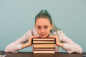 beautiful young woman sits at a table with books