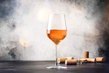 Orange wine in big wine glass, fashionable modern drink, gray counter background, copy space,...