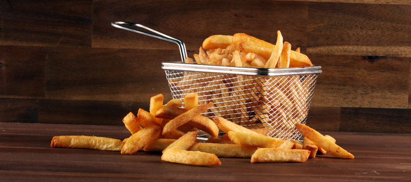 Tasty french fries potato on wooden table background