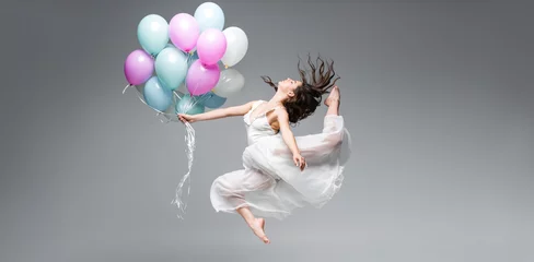 Poster panoramic shot of graceful ballerina dancing with festive balloons on grey background © LIGHTFIELD STUDIOS