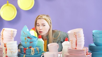 Displeased emotional depressed frustrated housewife washing dishes. Housewife expresses negative emotion