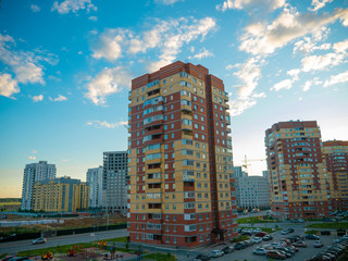 Fototapeta na wymiar Brick house in a residential quarter against a beautiful blue sky
