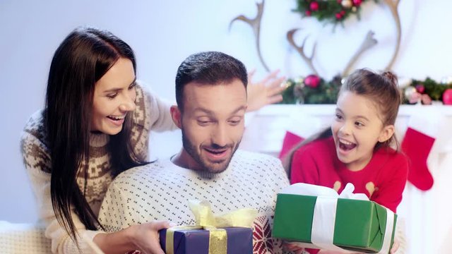 woman and kid giving presents to man 