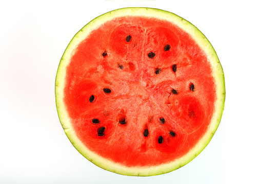 Half of juicy, red watermelon on a white background, texture of juicy pulp and mesmeses of ripe watermelon