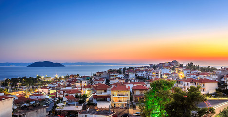 Fototapeta na wymiar Late golden hour view of amazing Neos Marmaras cityscape and distant turtle island in Greece