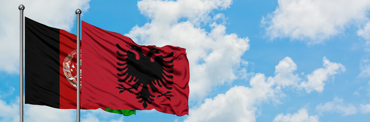 Afghanistan and Albania flag waving in the wind against white cloudy blue sky together. Diplomacy...