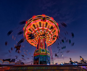 Chain carousel ride at evening hour from lower perspective.