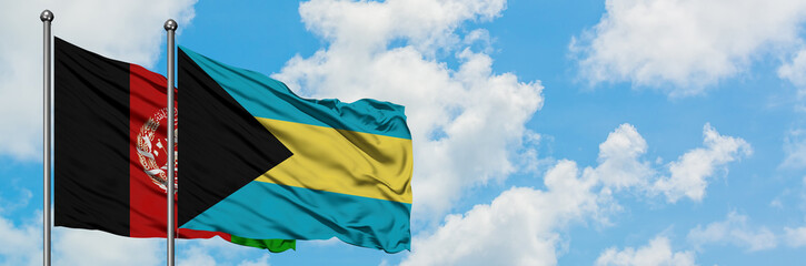 Afghanistan and Bahamas flag waving in the wind against white cloudy blue sky together. Diplomacy...