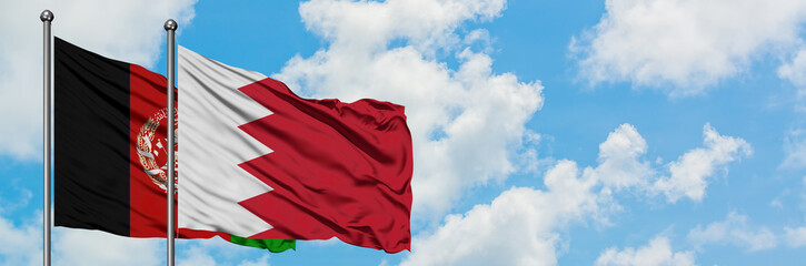 Afghanistan and Bahrain flag waving in the wind against white cloudy blue sky together. Diplomacy...