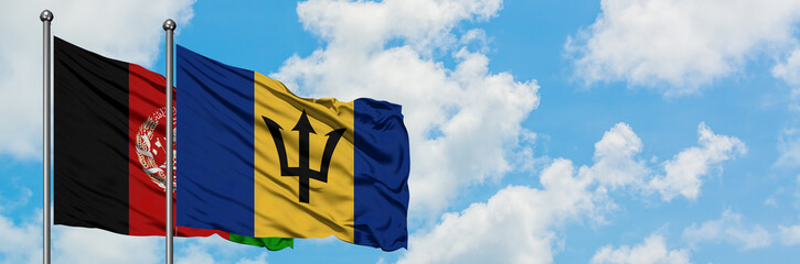 Afghanistan and Barbados flag waving in the wind against white cloudy blue sky together. Diplomacy...